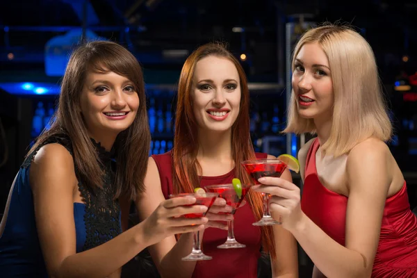 Drie meisjes aan de orde gesteld hun bril in een nachtclub — Stockfoto