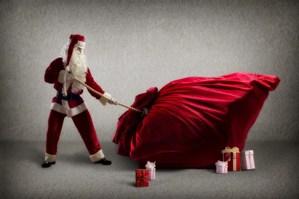 Santa Claus pulls a huge bag of gifts — Stock Photo, Image