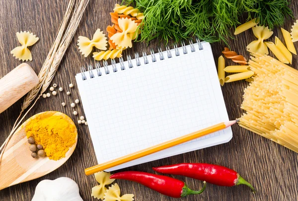 Spices and vegetables around notebook — Stock Photo, Image