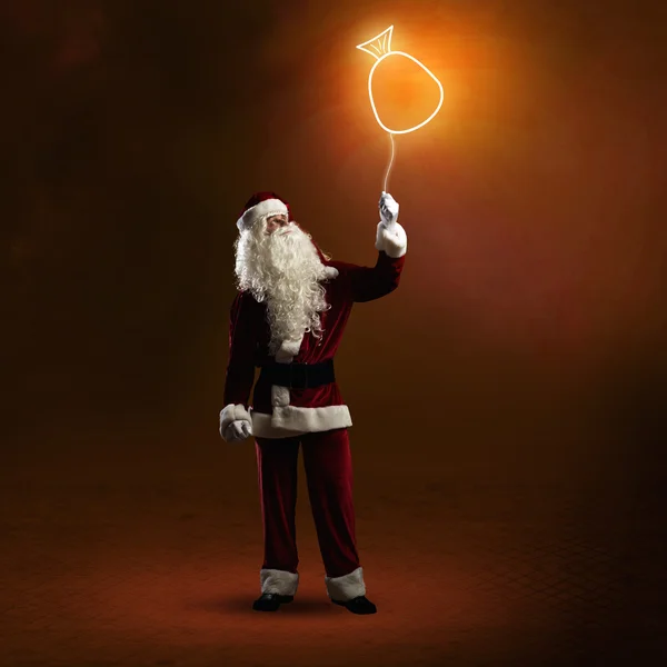 Санта Клаус держит сверкающую сумку — стоковое фото
