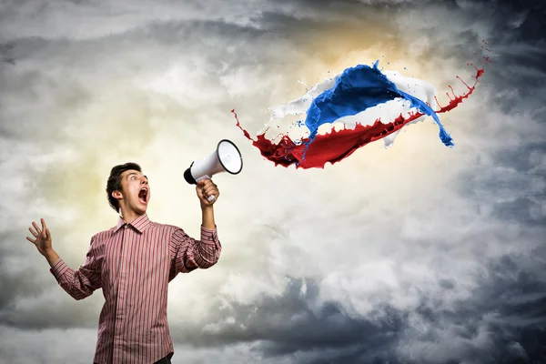 Young man shouting using megaphone