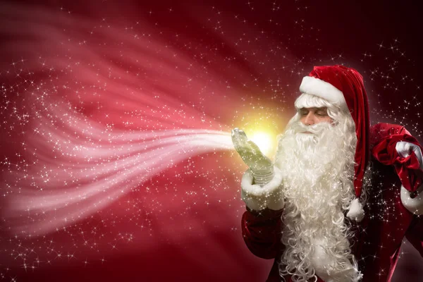Santa Claus blows with hands magic sparks — Stock Photo, Image
