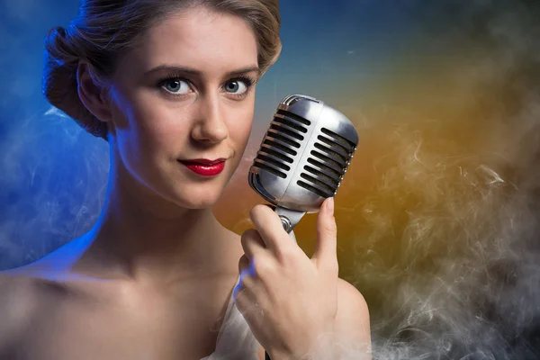 Atraktivní zpěvačka s mikrofonem — Stock fotografie