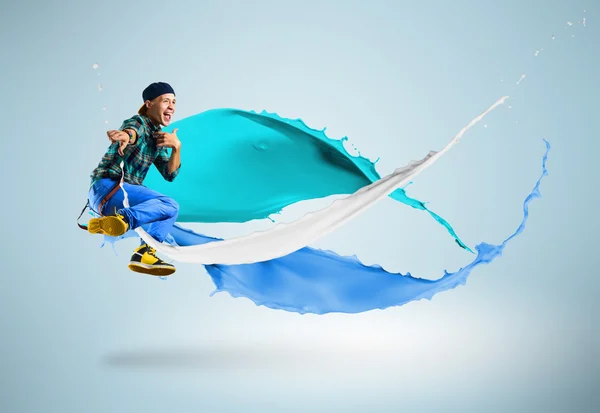 Junge männliche Tänzerin springt mit Farbspritzer — Stockfoto