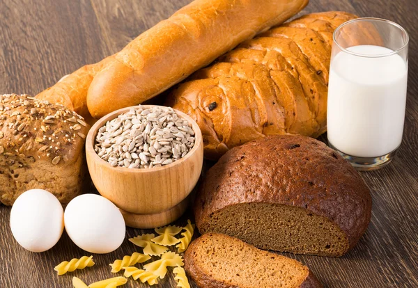 Pan fresco, huevos y vaso de leche y granos . —  Fotos de Stock