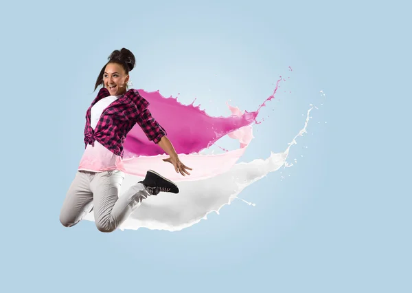 Young female dancer jumping with splash of paint — Stock Photo, Image