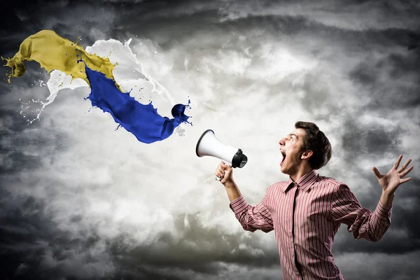 Man yells into a megaphone — Stockfoto