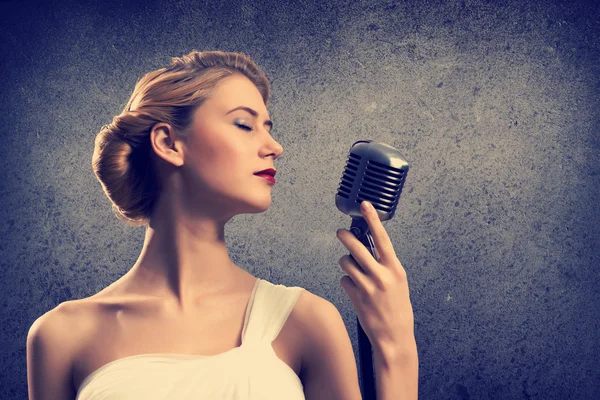 Attractive female singer with microphone Stock Image
