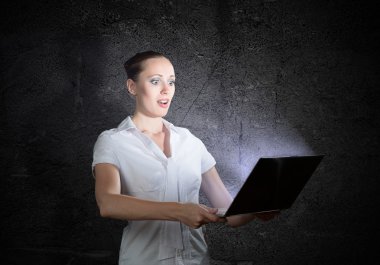 bir laptop tutan kadın
