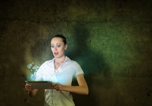 Woman holding a tablet in a dark room — Stock Photo, Image