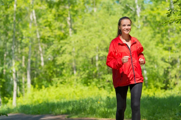 Atleta donna che corre in un parco — Foto Stock