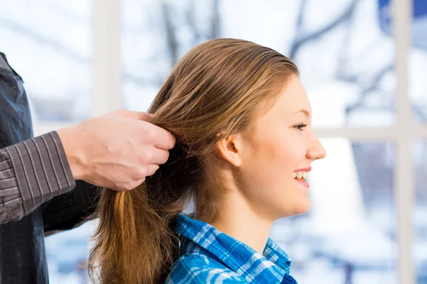 Male hairdresser puts woman's hair — Stock Photo, Image