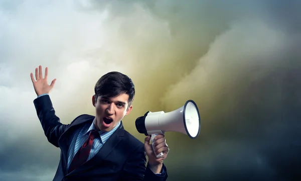 Businessman shouting into a megaphone — Stock Photo, Image