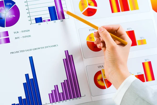 Weibliche Hand auf Finanzcharts — Stockfoto