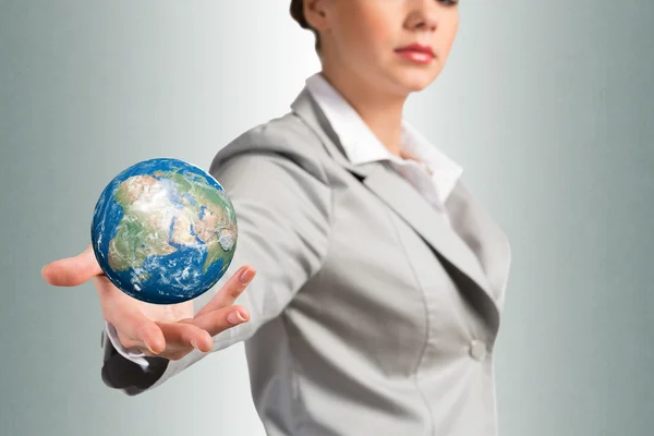 Businesswoman holds up an Earth — Stock Photo, Image