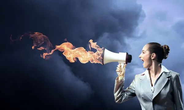 Business woman shouting into a megaphone — Stock Photo, Image