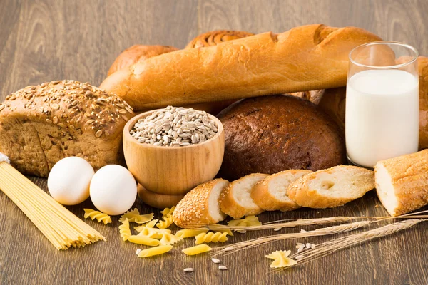 Fresh bread, eggs and glass of milk and grains. — Stock Photo, Image