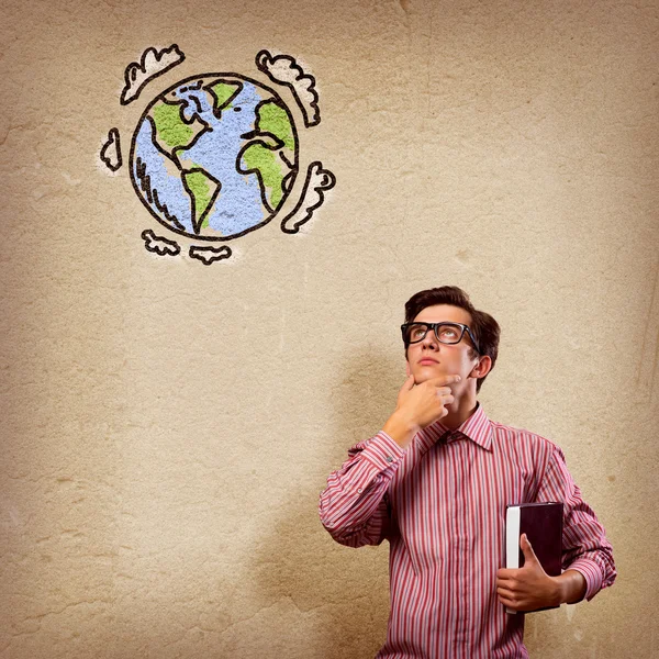 Young man with a book thinks — Stock Photo, Image