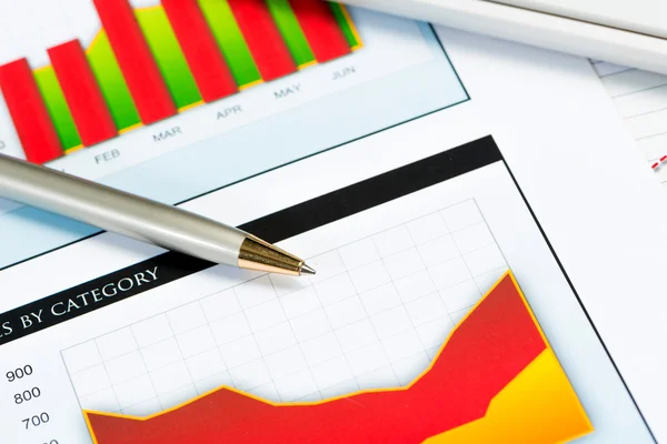 Close-up of pen and financial growth charts — Stock Photo, Image