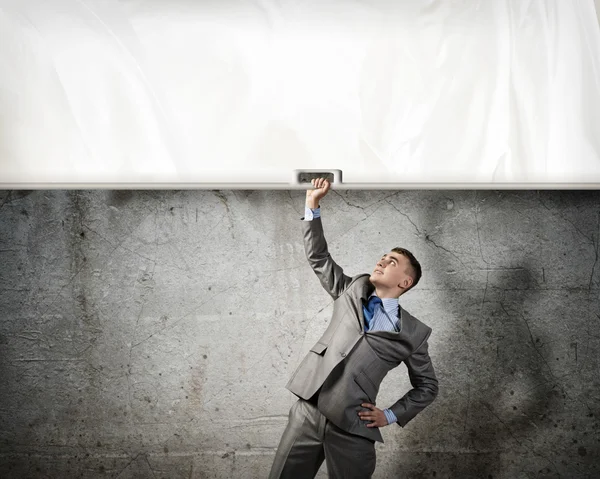 Businessman holding a banner with one hand — Stock Photo, Image