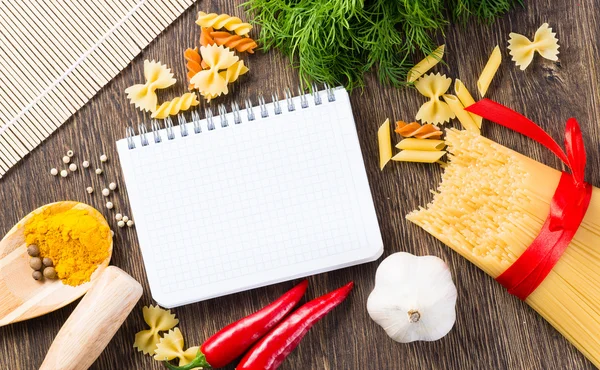 Spices and vegetables around notebook — Stock Photo, Image