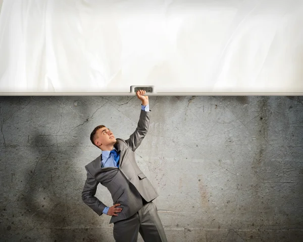 Businessman holding a banner with one hand — Stock Photo, Image