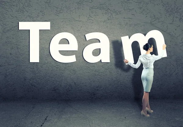 Young businesswoman adds team word — Stock Photo, Image
