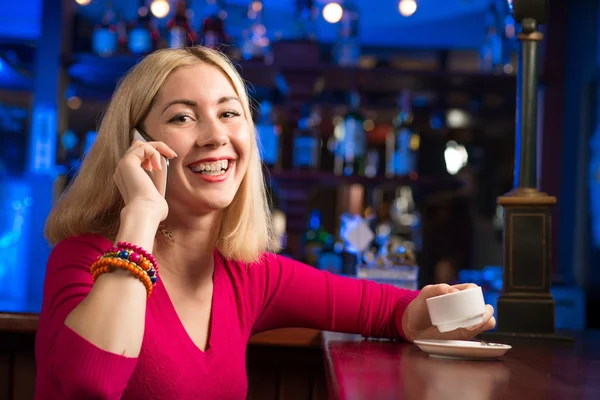 Bir fincan kahve ve cep telefonu olan kadın — Stok fotoğraf