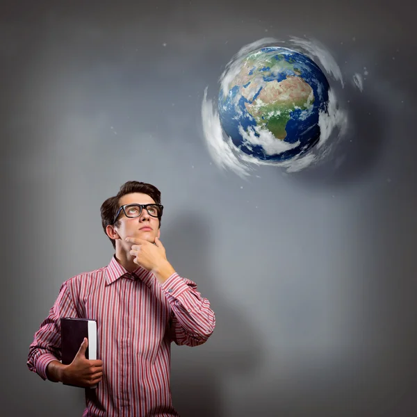 Young man with a book thinks — Stock Photo, Image