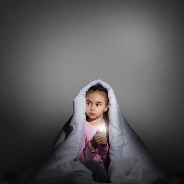 Menina sob as tampas com uma lanterna — Fotografia de Stock