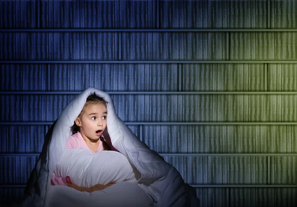 Girl under the covers with a flashlight — Stock Photo, Image