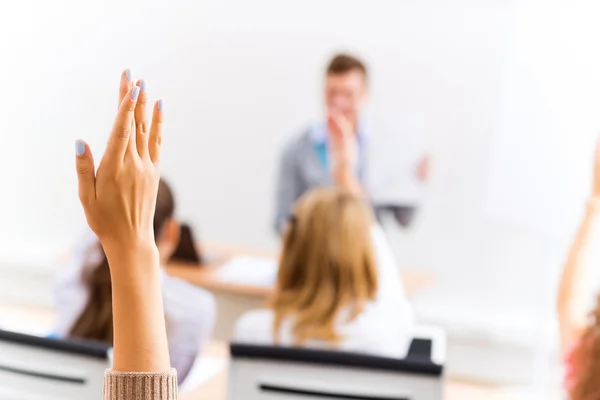 Mano femminile alzata in classe — Foto Stock