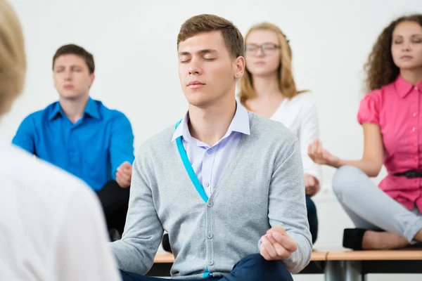 Grupp unga människor mediterar — Stockfoto