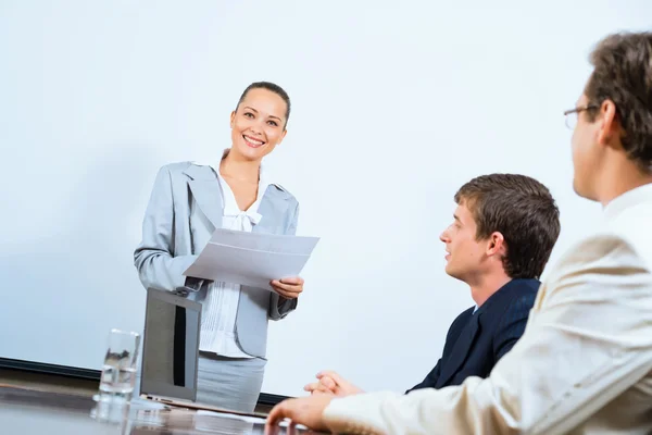 Discusses business woman with colleagues — Stock Photo, Image