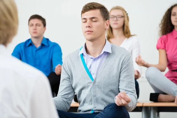 Grupp unga människor mediterar — Stockfoto