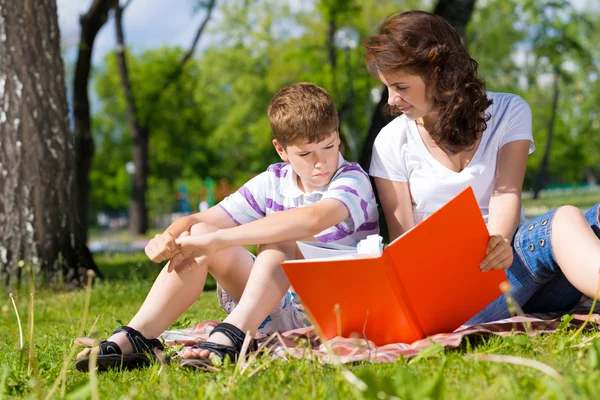 Junge und Frau lesen gemeinsam ein Buch — Stockfoto