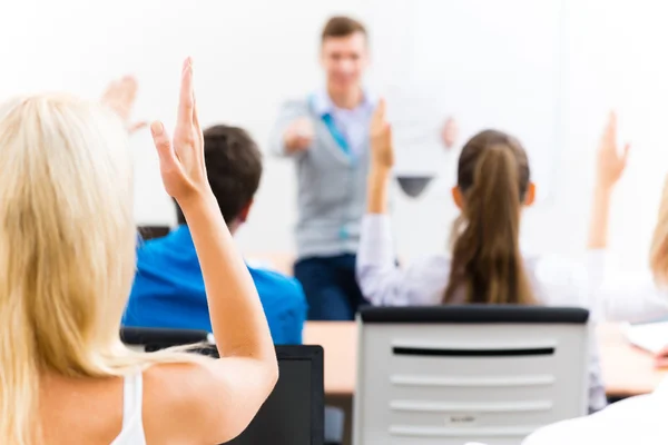 Mano femenina levantada en clase — Foto de Stock