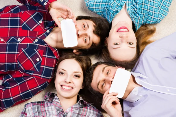 Quatro jovens jazem juntos — Fotografia de Stock