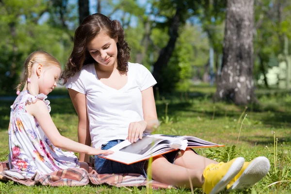 Girl with the teacher reading a book — Stock Photo, Image