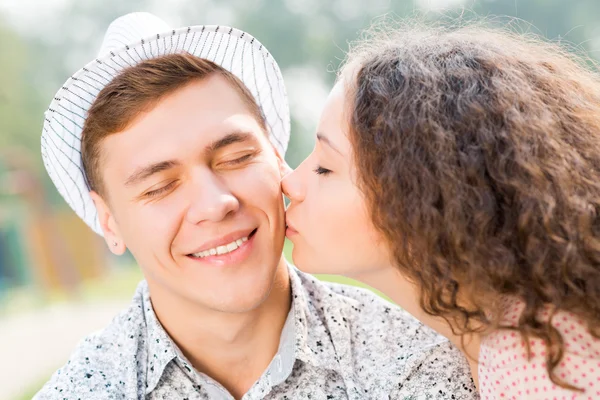 Girl kissing a man on the cheek — Stock Photo, Image