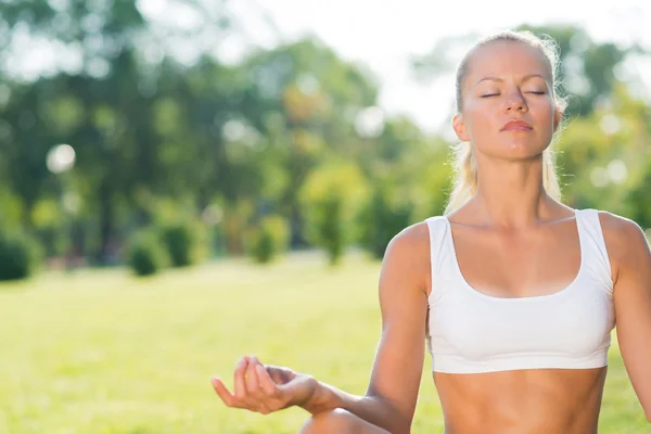 Kvinna som gör yoga i parken — Stockfoto