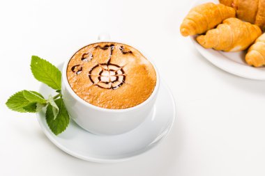 büyük bir fincan kahve ve kruvasan bir plaka üzerinde
