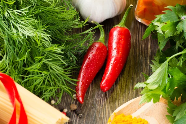 Chilli, herbs and spices lie on a wooden surface — Stock Photo, Image