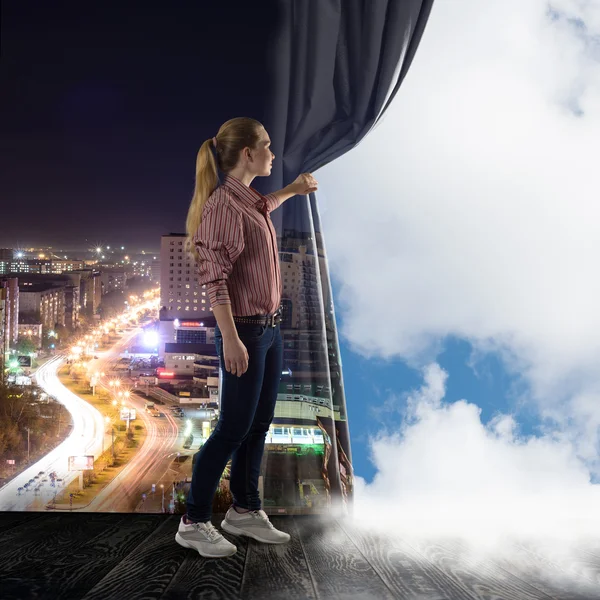 Junge Frau schiebt den Vorhang und blickt auf Wolken — Stockfoto