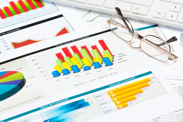 Glasses, business papers with charts — Stock Photo, Image