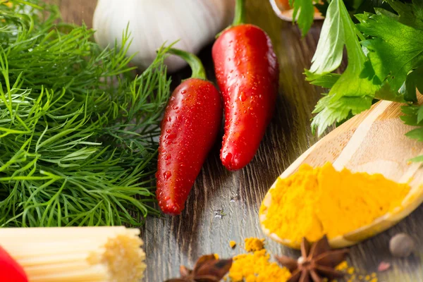 Chilli, urter og krydder ligger på treoverflate – stockfoto
