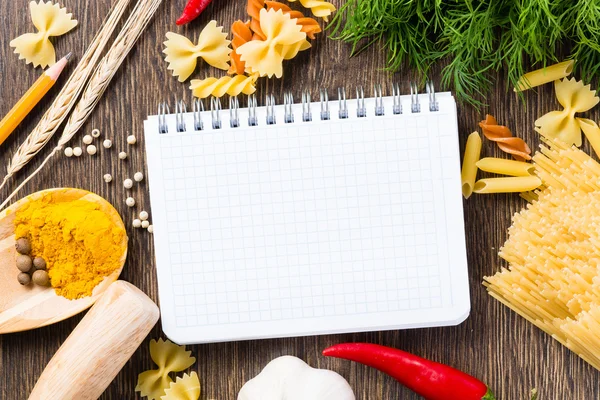 Spices and vegetables around notebook — Stock Photo, Image