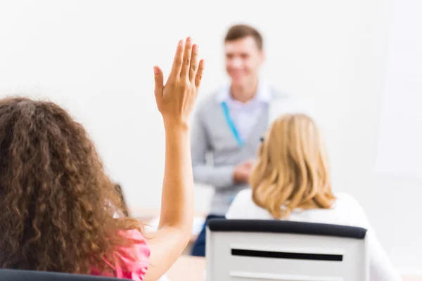 Mano femminile alzata in classe — Foto Stock