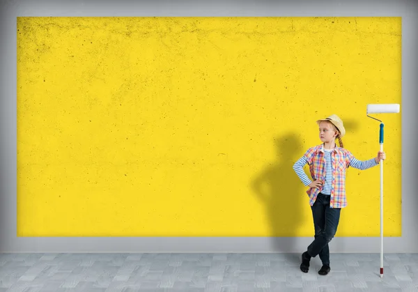 girl in a hat with a roller for painting