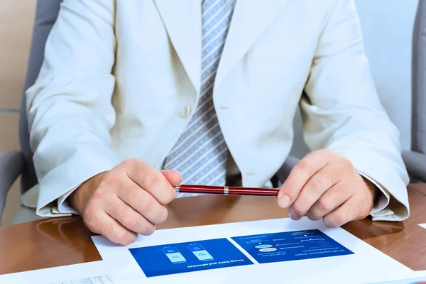 Zakenman een pen in de hand houden — Stockfoto